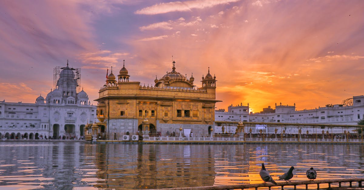 Eating on the Palace on Wheels, in Rajasthan, India if I have dietary restrictions - Exterior of Sikh gurdwara golden temple with dome located near water against cloudy sky in evening time in city in India