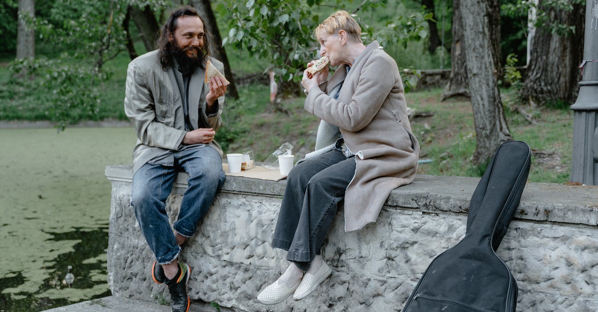 Eating while out on a public street in Japan - Man and Woman Eating at a Park