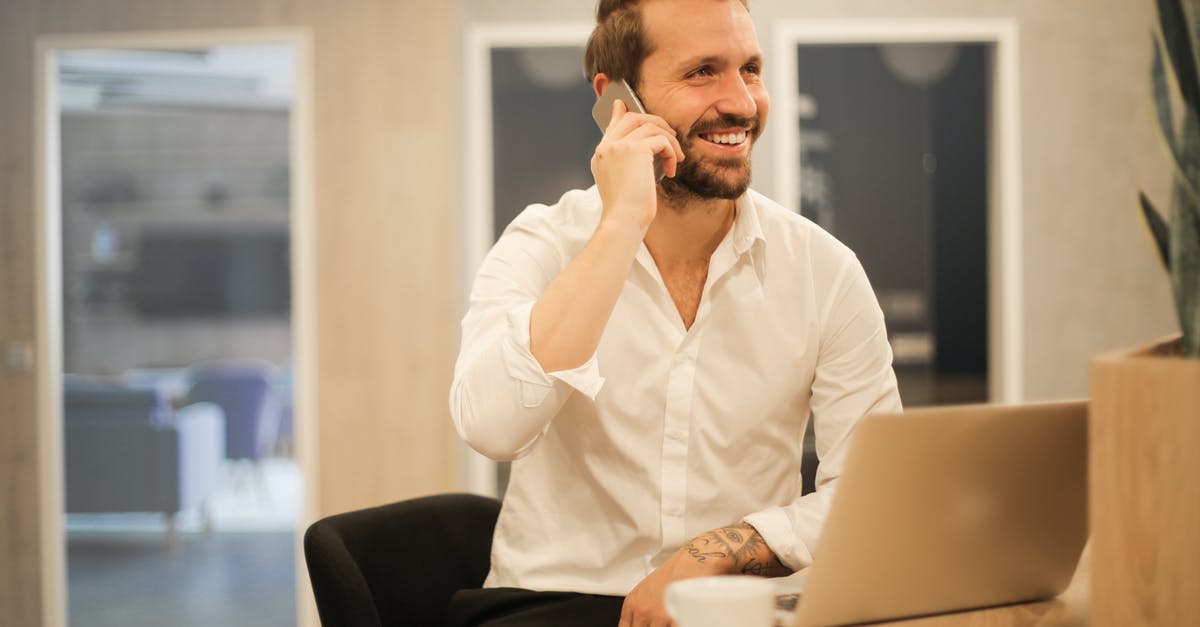 eBoarding passes of all family members on a single smartphone? - Smiling formal male with laptop chatting via phone