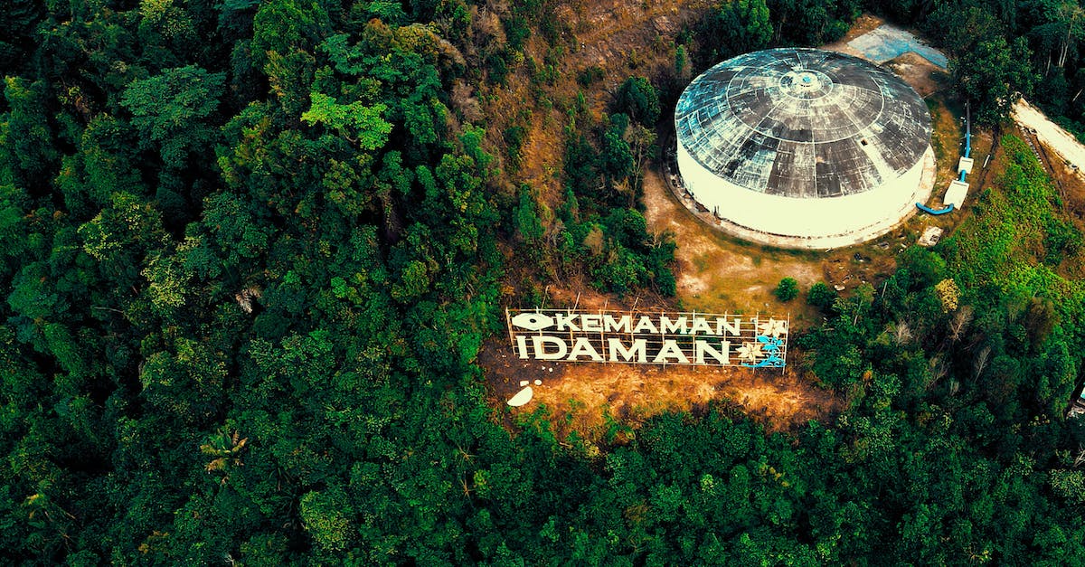 Eco touring/diving in Malaysia - Drone view of picturesque view of hilltop with high green woodland located around stone water tank in Kemaman district in Terengganu Malaysia