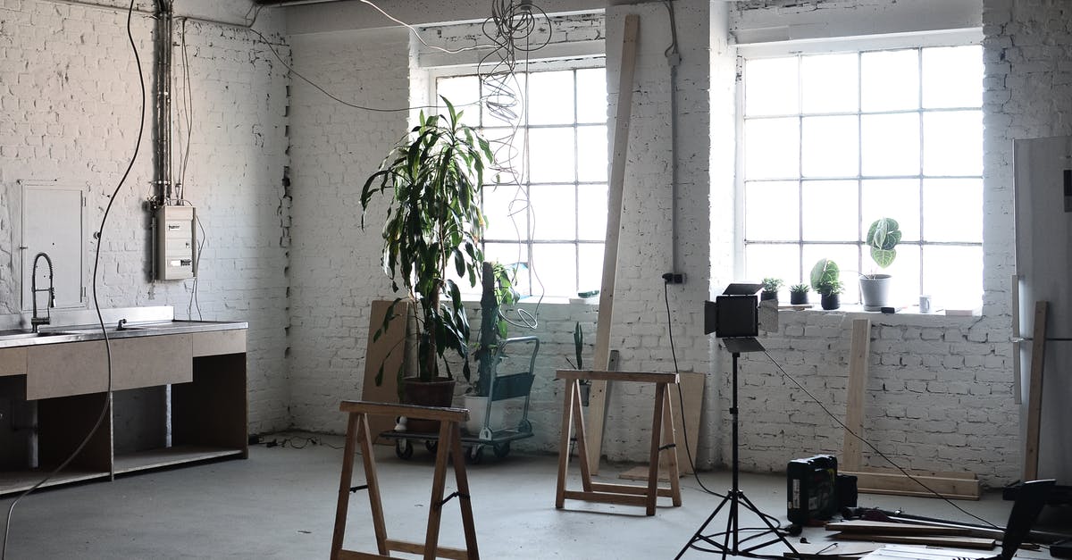 Effect of Schengen visa refusal on residence renewal in the UK? - Interior of loft with brick wall with wires hanging on ceiling and tools for renovation  works