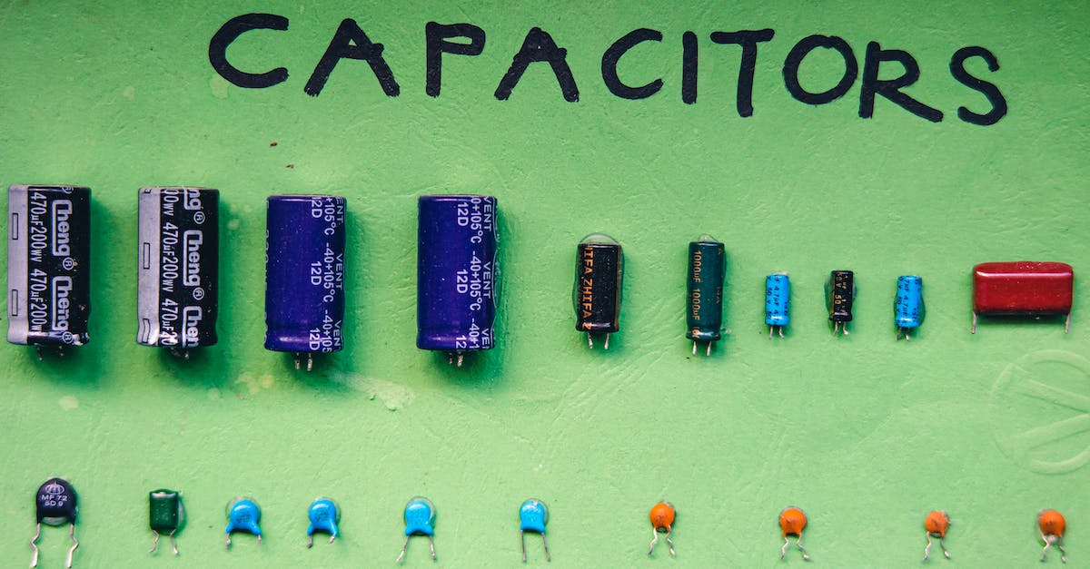 Electrical compatibility between different countries - Top view layout of various capacitors for storing electrical energy of different sizes and capacities arranged on green background with inscription