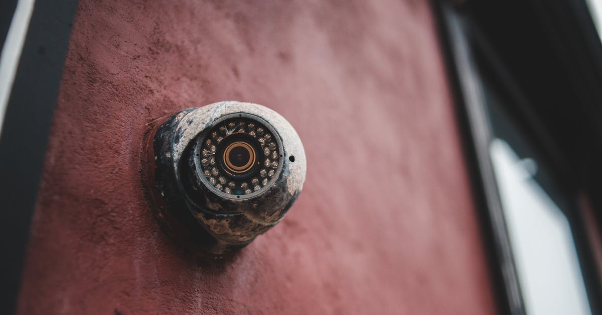 Electronic Devices and airport security checks [duplicate] - Old security camera on shabby building wall