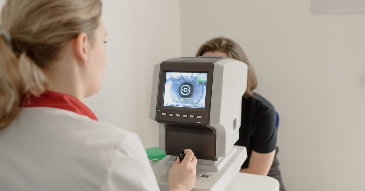 Electronic medical devices through British airport security - Anonymous oculist examining vision of patient on eye screener