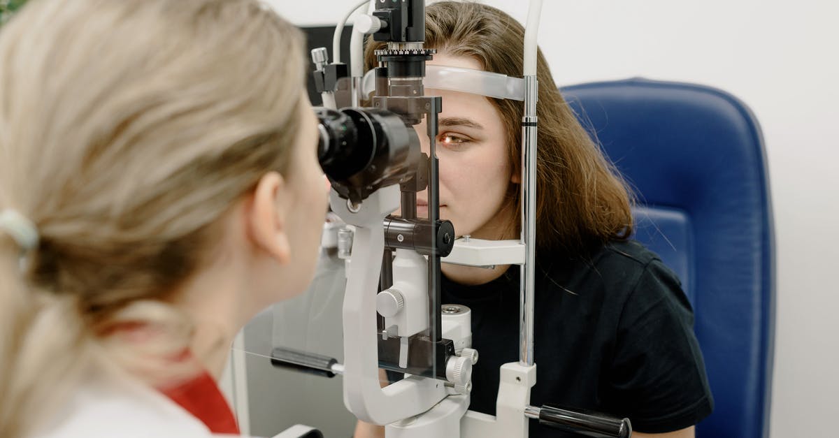 Electronic medical devices through British airport security - Female doctor using modern medical device for female patient while checking eyesight in clinic during check up