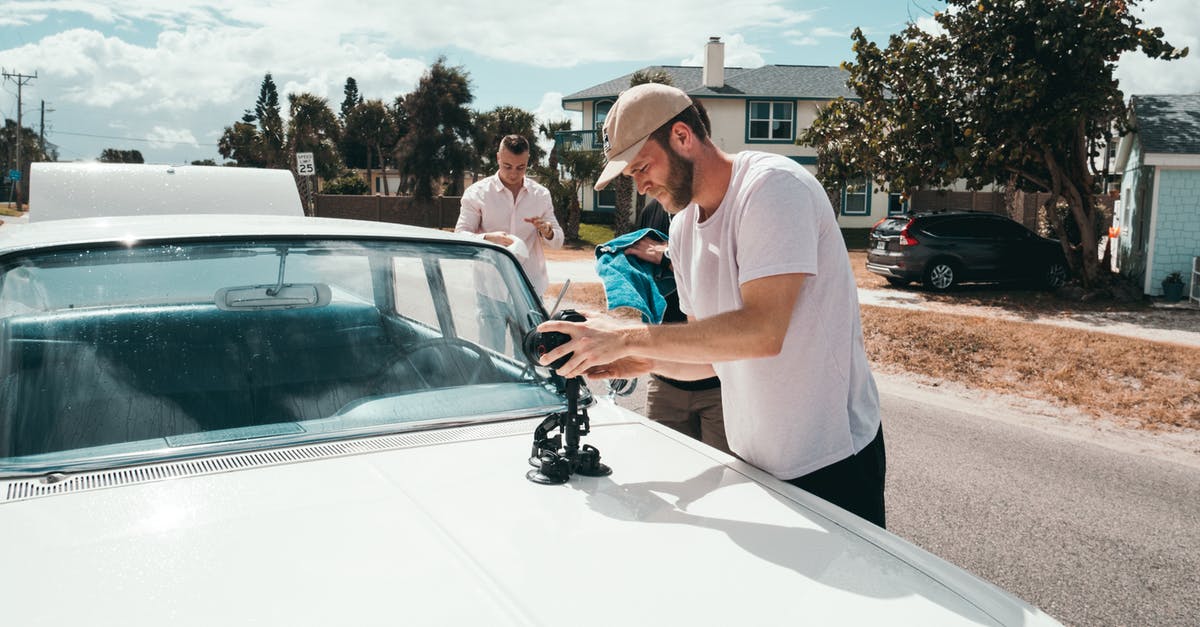 Electronic road tolls (cashless) in Florida - Man Wears White Crew-neck T-shirt Holding Camera on White Vehicle