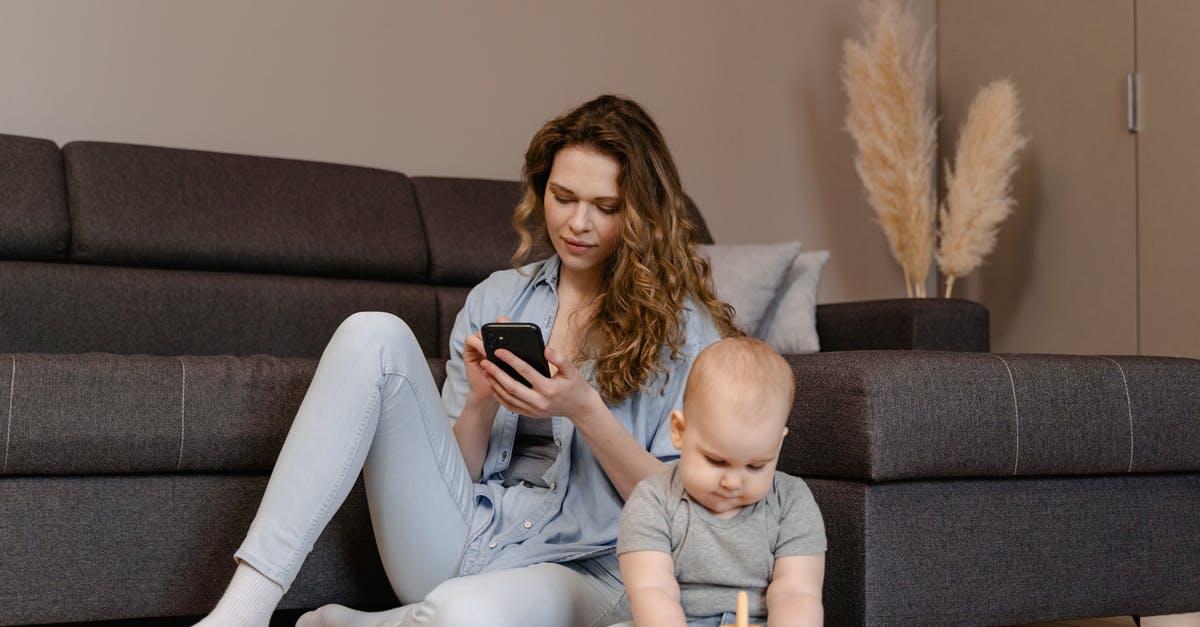 Eligibility to Invite Parent to Visit UK - Woman in Gray Long Sleeve Shirt and White Pants Sitting on Gray Couch