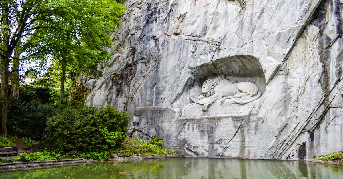 Elm, Switzerland - Suvorov monument and Glarus thrust - Sculpture of a mortally wounded lion carved into sheer rock ledge near pond located in Switzerland