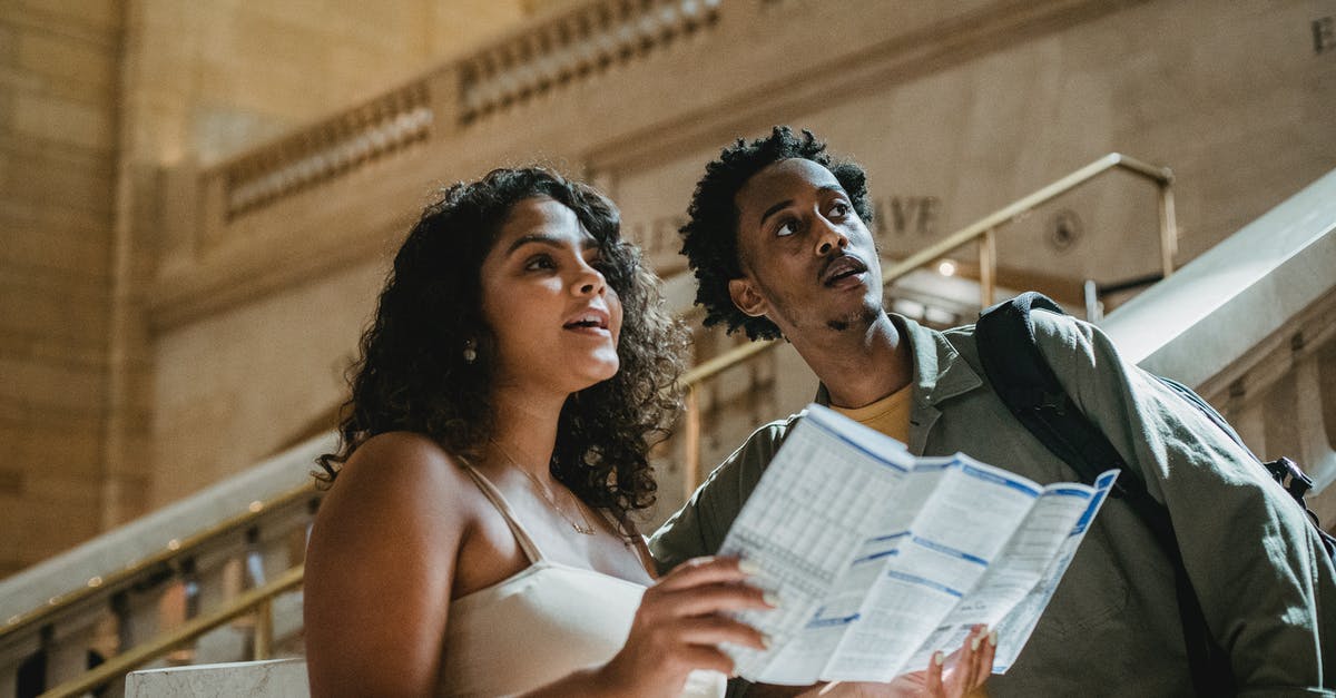 Embassy background check [closed] - Concentrated young multiethnic couple reading map during romantic trip