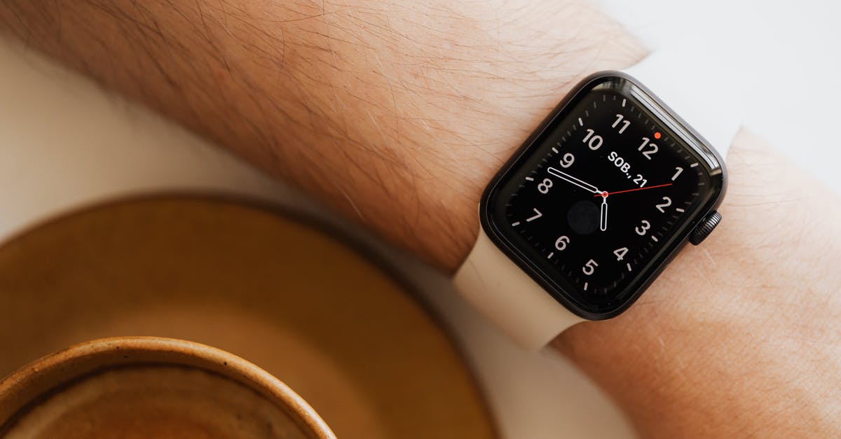 Embassy background check [closed] - From above closeup of crop man hand with smart watch near cup of hot americano on white background