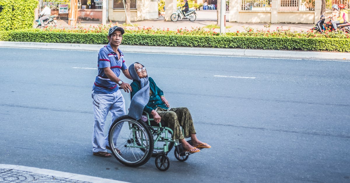 Emergency UK visa for an Australian to visit a critically ill parent - Man Pushing A Woman Sitting on Wheelchair Emergency UK visa for an Australian to visit a critically ill parent - Man Pushing A Woman Sitting on Wheelchair