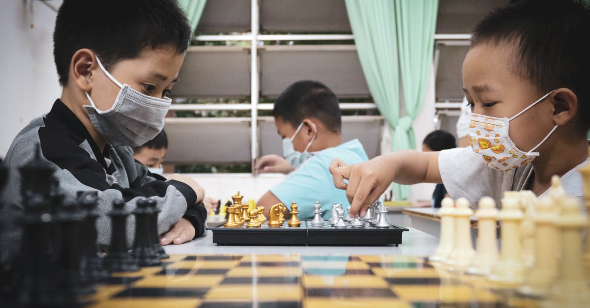 Emirates OK to Board - Boy in White T-shirt Playing Chess