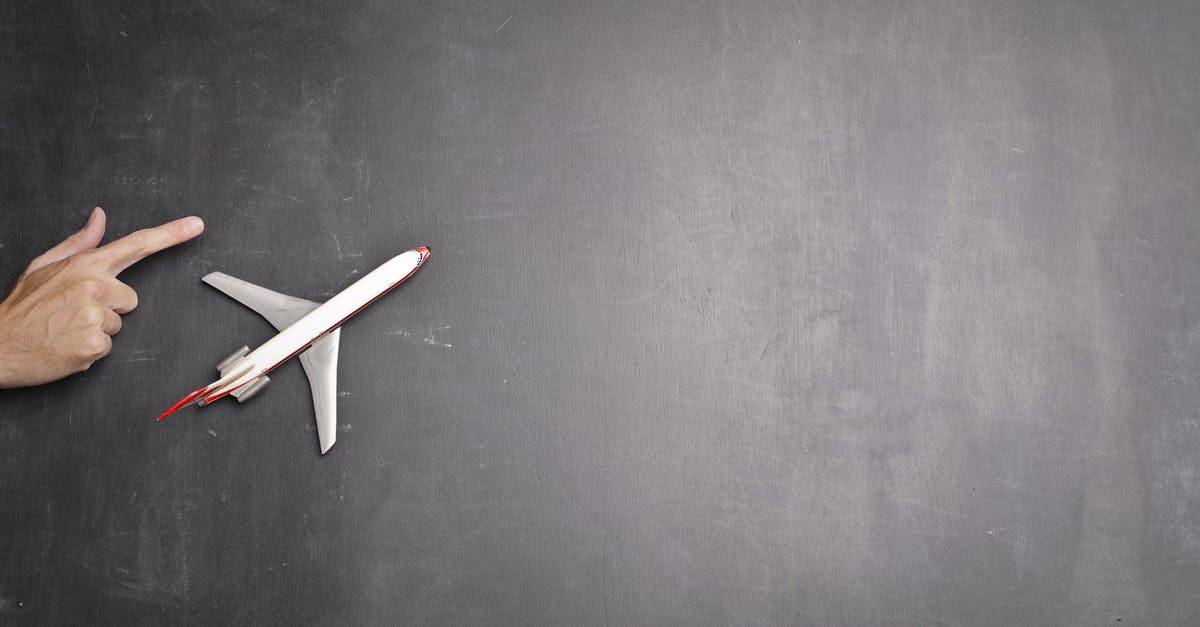 Empty suitcase on flight - Toy plane and human hand on chalkboard