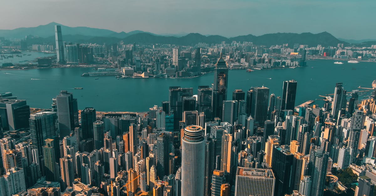 Enter China (from European Union), after being fined in Hong Kong a few years ago - From above of contemporary skyscrapers of modern megapolis located on shore of river against blue sky