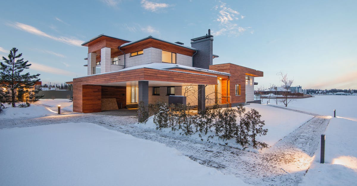 Enter UK under new EU citizenship after ban - Exterior view of luxurious residential house with roofed parking and spacious backyard in snowy winter countryside