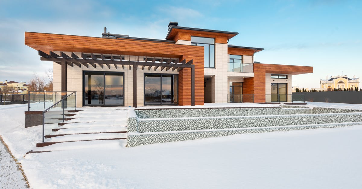 Entering another Schengen Country from India on EU / EAA Residence Permit - Exterior view of contemporary residential house with terrace and large windows located in suburban area in winter day