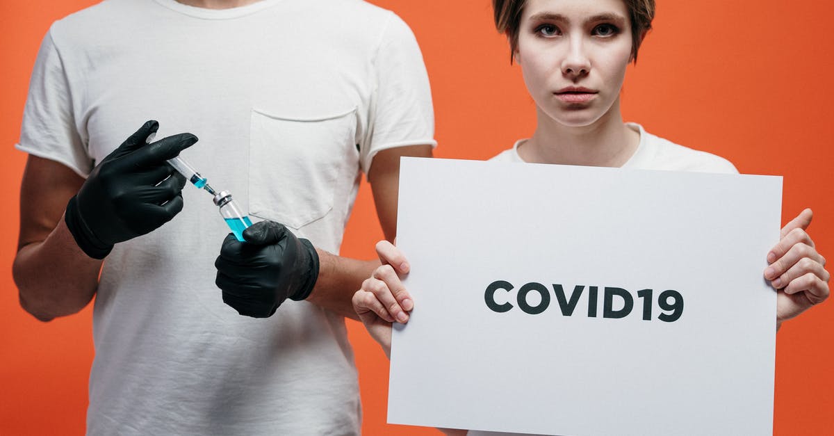 Entering France beyond vaccine certificate validity period - Man Holding A Vaccine With Woman Holding A Covid19 Poster