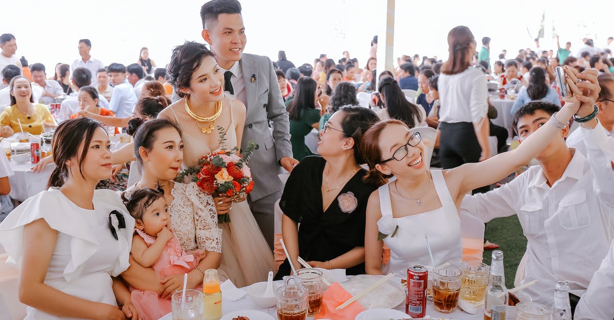 Entering Schengen area 5 days before the Visa date starts - Group of happy friends in elegant clothes taking selfie with newlyweds on wedding party