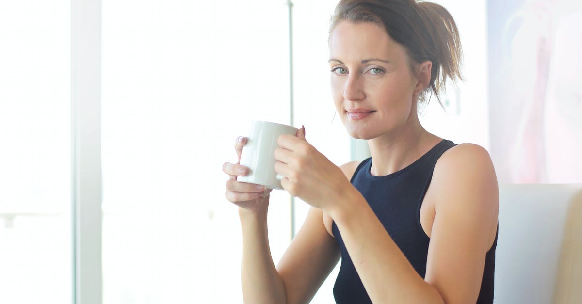 Entering UK for leisure while holding a business visa - Woman in Black Tank Top Holding White Ceramic Cup