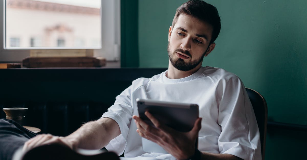 Entering UK for leisure while holding a business visa - Man in White Shirt Holding an Ipad