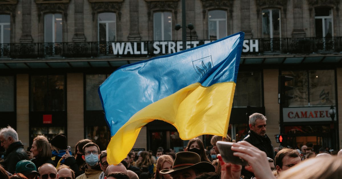 Entering Ukraine as a Ukrainian born, naturalised British citizen - Blue and yellow Ukrainian Flag Waving Above Crowd of People