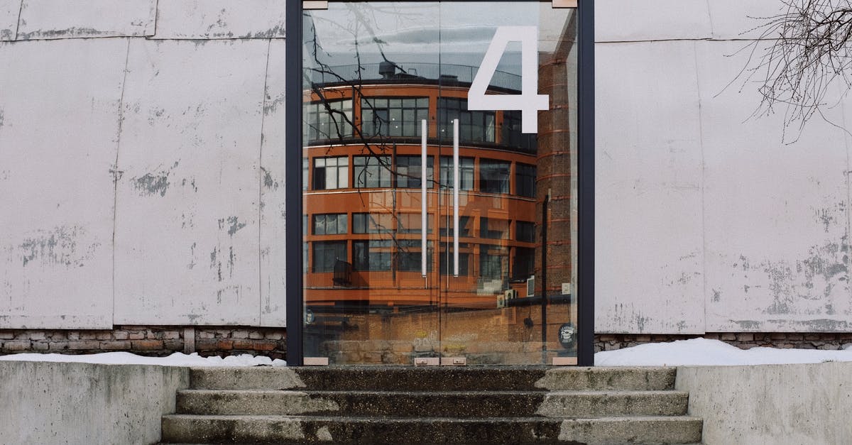 Entry and exit from different Schengen countries - From below of modern building facade with number four on glass entrance door and stairs