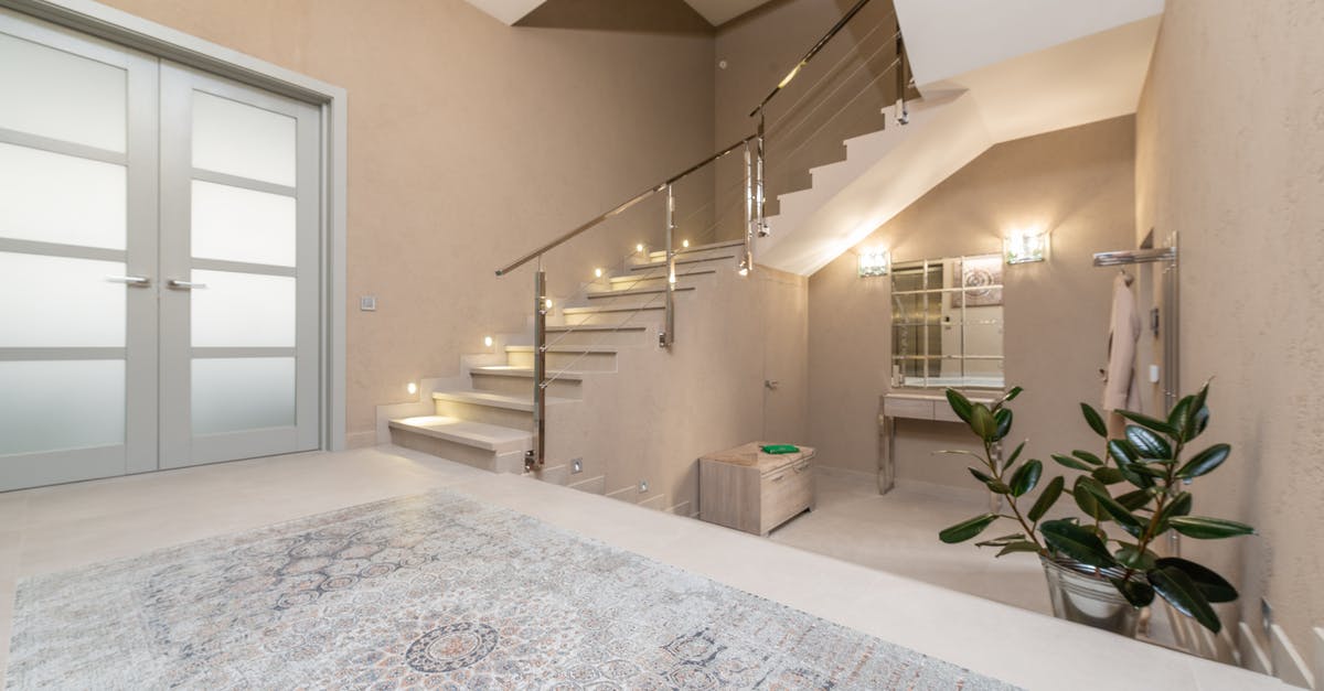 Entry and exit stamps in Schengen-UK-Schengen - Interior of modern light lobby with beige walls and big glass doors with luminous stairway to second floor