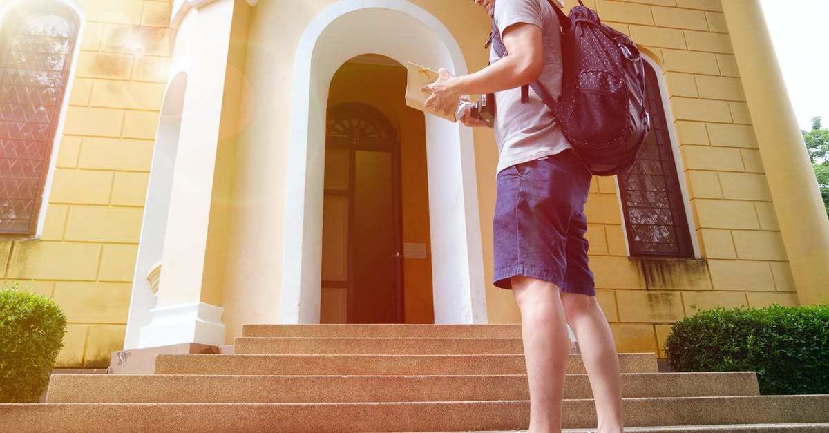 Entry as tourist with intent to stay as student [closed] - Man Standing and Facing in Front of a Beige House