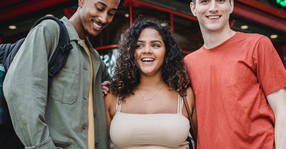 Entry as tourist with intent to stay as student [closed] - Happy multiracial friends hugging near building in street