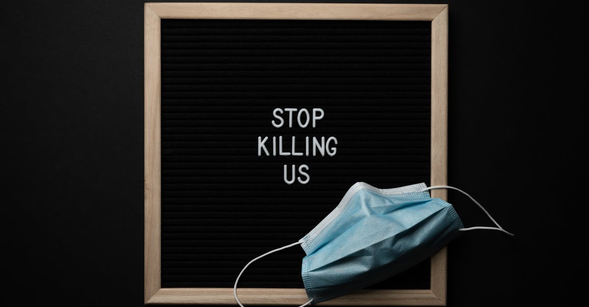 Entry quarantine for entering the United States - Top view of composition of blackboard with written phrase STOP KILLING US under mask against black background