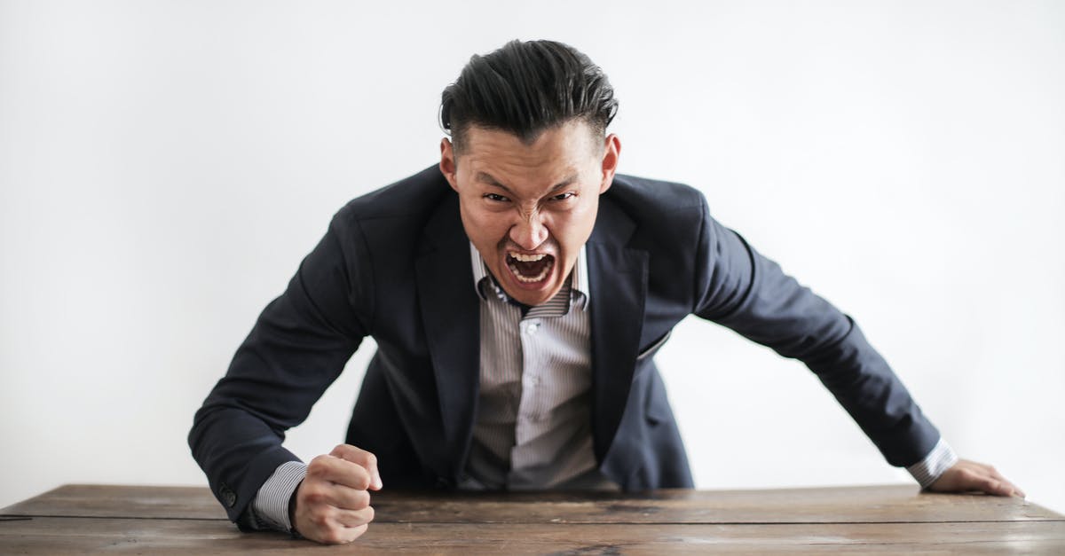 Error in SSR CKIN command? - Expressive angry businessman in formal suit looking at camera and screaming with madness while hitting desk with fist