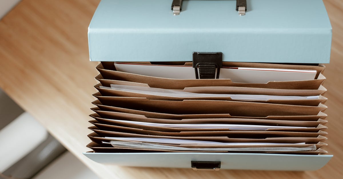 ESTA application paperwork - From above of briefcase for documents with papers placed on wooden table in daytime