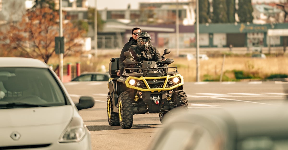 ESTA: Do I need to tell all my trip itinerary? - Unrecognizable friends riding quad bike on city road in sunlight