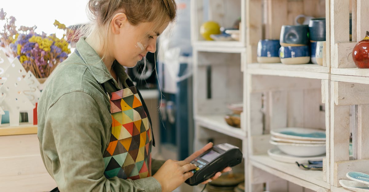 ESTA payment not processed - Woman in Green Jacket Holding Black Smartphone