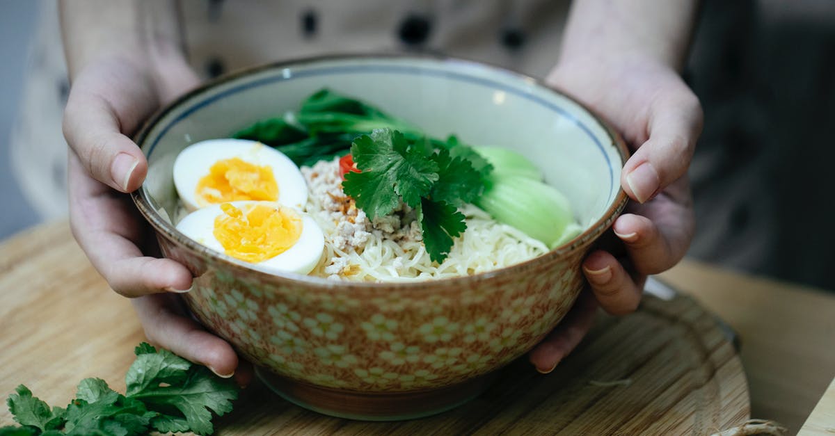 Etiquette of eating noodle soup in China - Crop unrecognizable woman touching bowl with traditional ramen soup