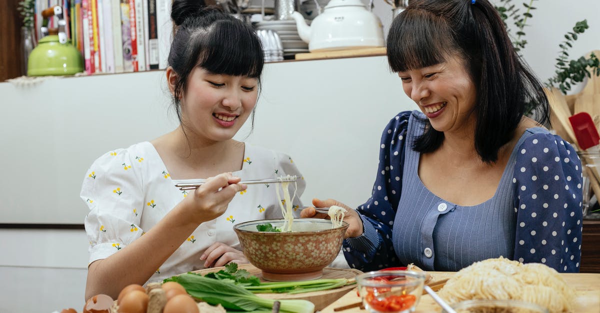 Etiquette of eating noodle soup in China - Joyful Asian women eating traditional noodles soup together