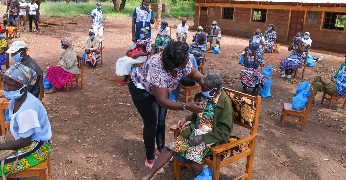 Etiquette when staying with an indigenous community - Black elderly people sitting on chairs in yard of hospital in poor African village