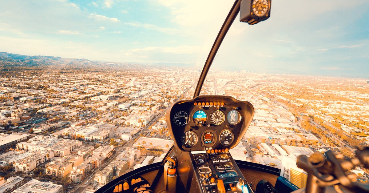 EU Air Passenger Rights for connecting flight - Crop anonymous female traveler sitting in cockpit of modern helicopter and admiring spectacular view of city on sunny day