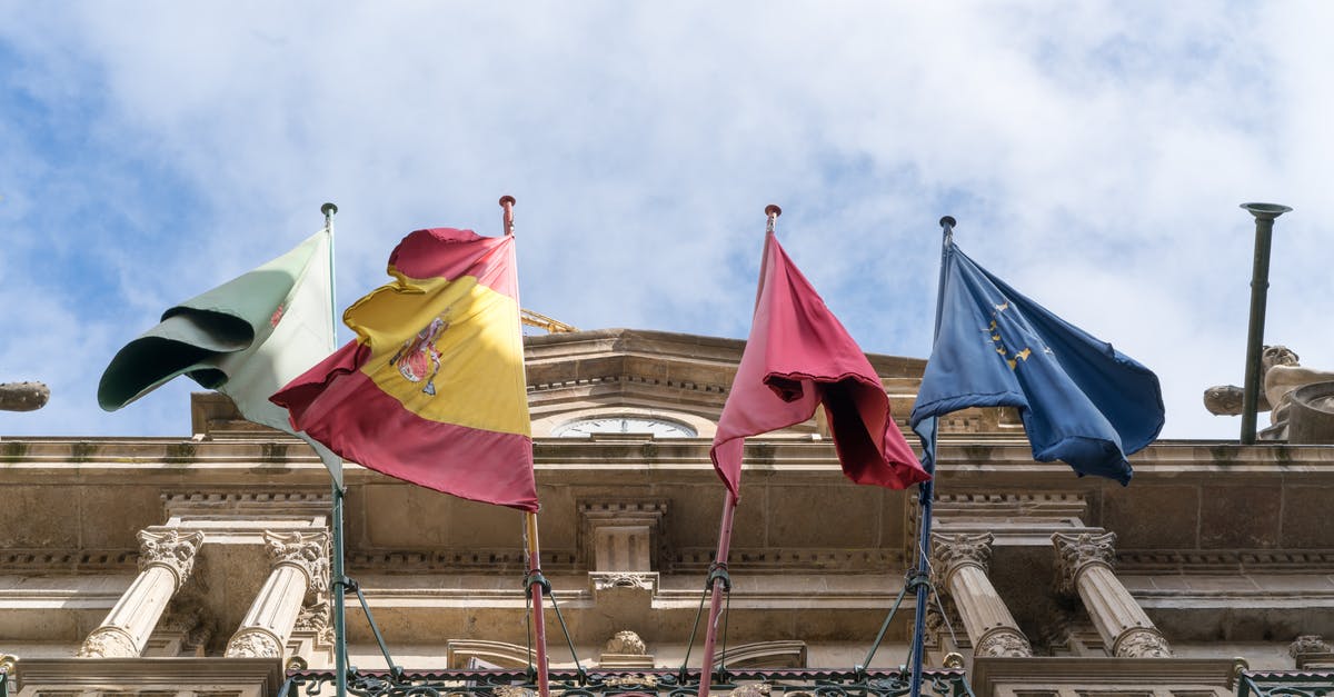 EU citizen and non-EU spouse entering the EU (Schengen area) - Flags waving on old ornate city building on fine day