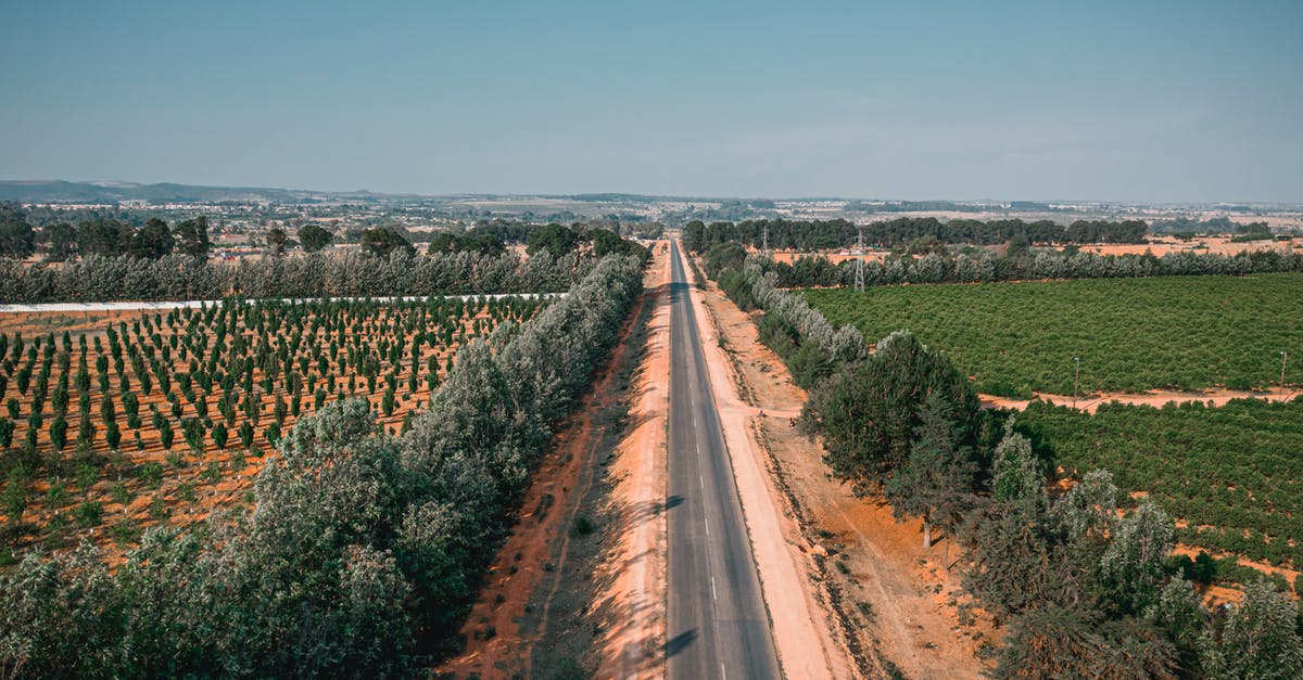 Europe: differences between colours of highway road-signs - Aerial Shot of a Road Between Farm Lands