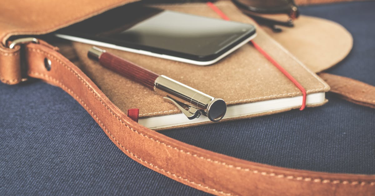 European SIM card in US mobile phone - Smartphone Displaying Black Screen on Notebook Beside Pen and Sunglasses