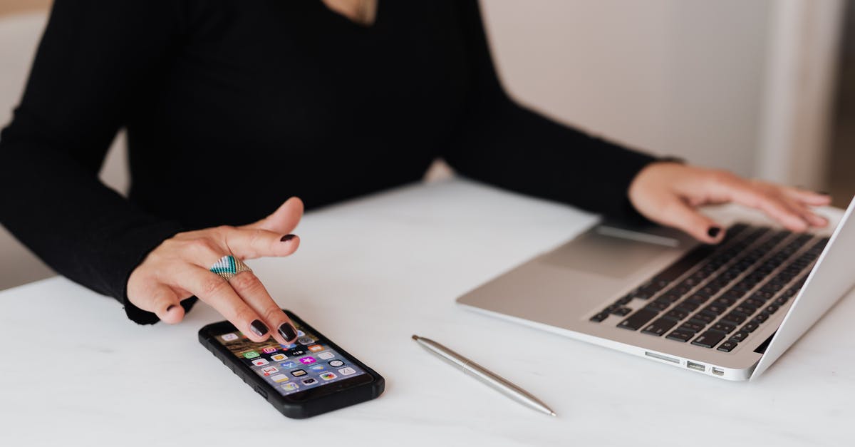 Europe-wide phone plan for a month - Crop woman using smartphone and laptop during work in office