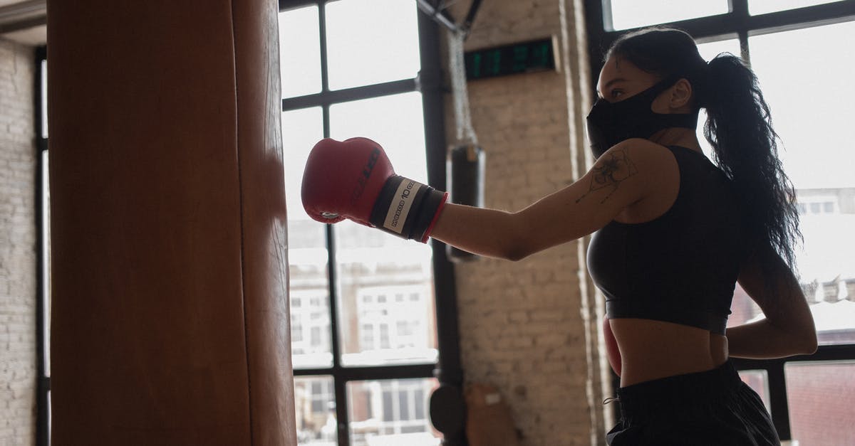 Eurostar train to Paris during a strike - Tattooed black boxer in face mask punching heavy bag indoors