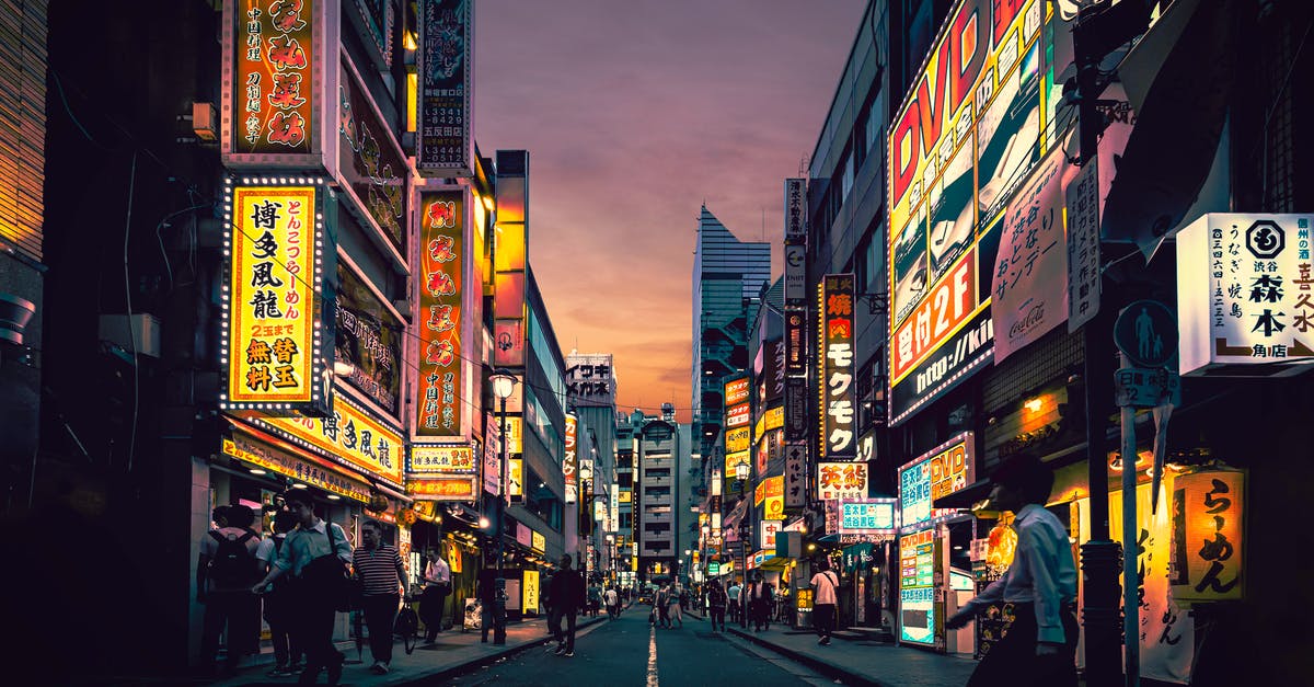 Exchanging business cards in Japan - People Walking on Street Near Buildings