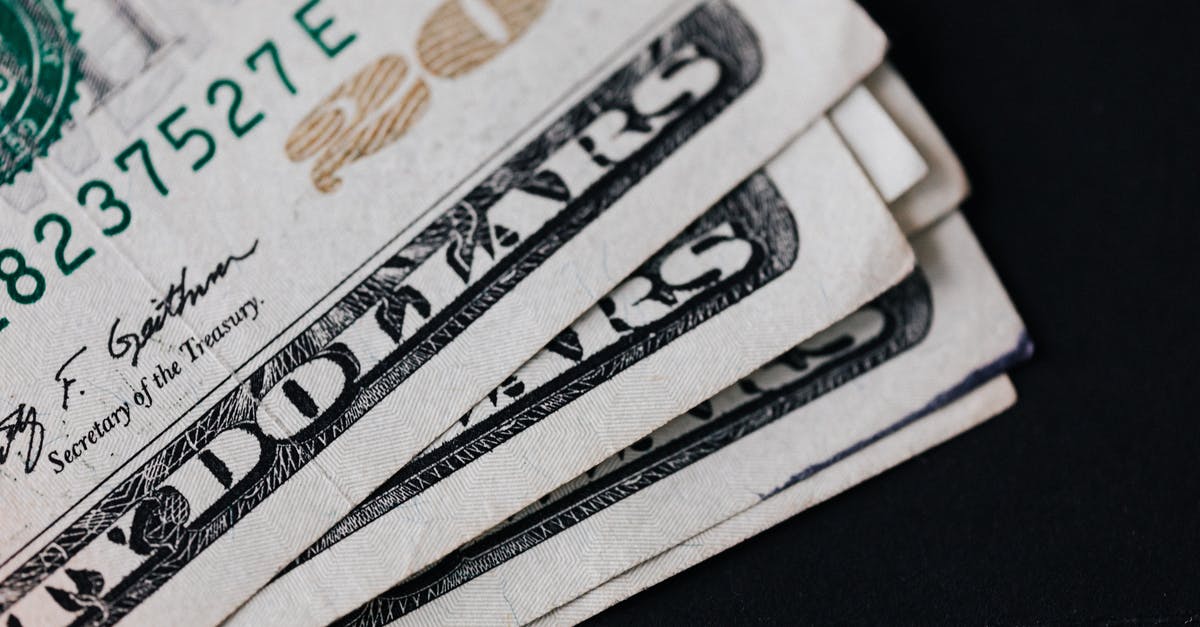 Exchanging Canadian dollars for Pound Sterling [closed] - Pile of American paper money on black surface