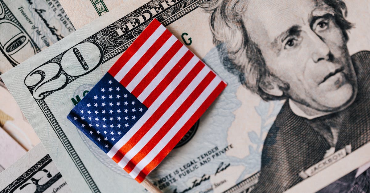 Exchanging older United States currency in Japan - From above of small American flag placed on stack of 20 dollar bills as national currency for business financial operations