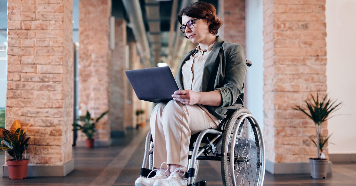 Exploring the Galapagos Islands with a Disabled Individual - Woman Sitting on Wheelchair While Using Laptop