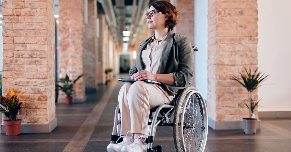 Exploring the Galapagos Islands with a Disabled Individual - Woman in Gray Coat Sitting on Wheelchair