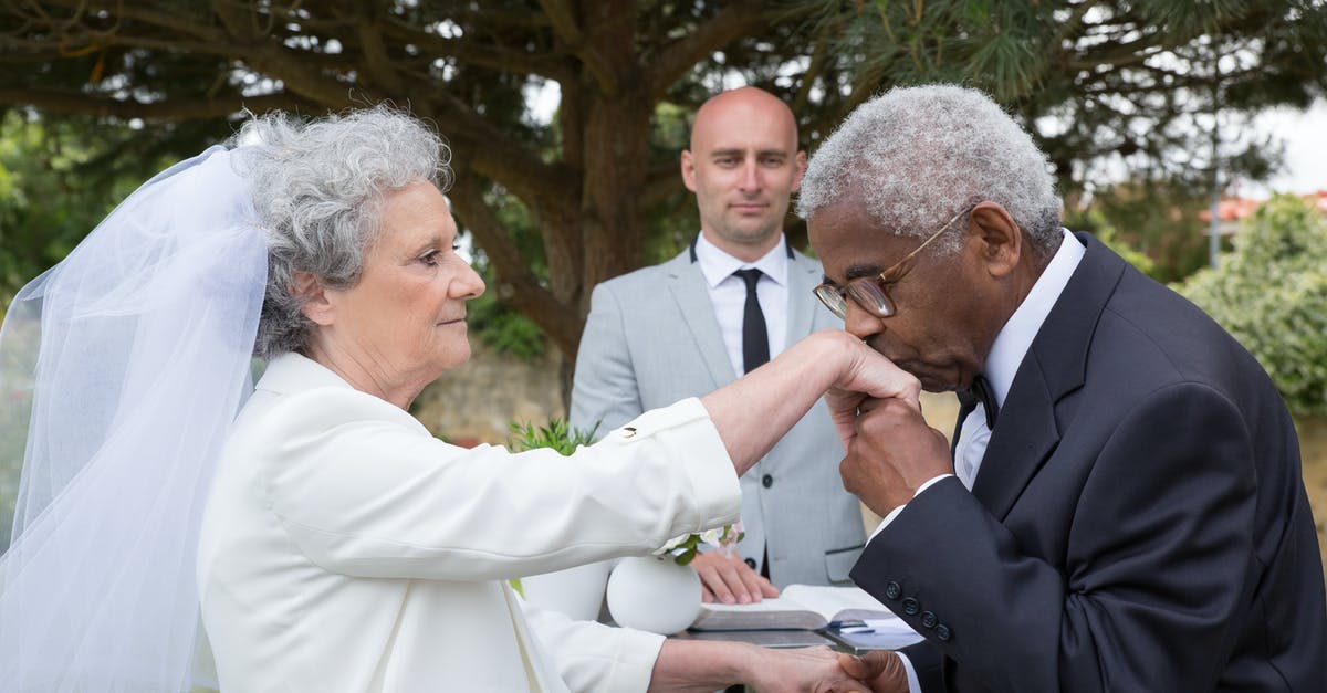 Extending a layover to the next day - Man in Black Suit Jacket Kissing Woman in White Dress