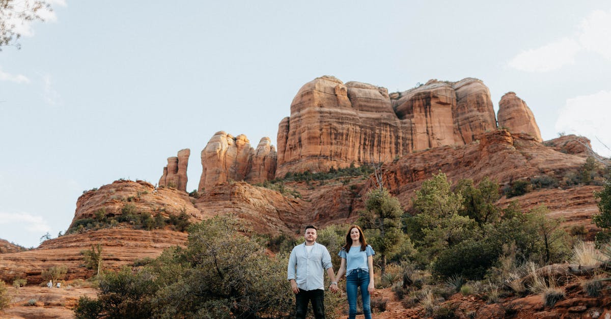 Extending visitor stay in the US - Man and Woman Standing on Brown Rock Formation